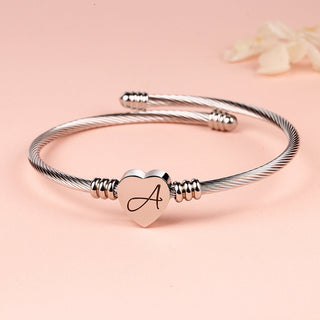 Pulseira de aço trançado com inicial em forma de coração 