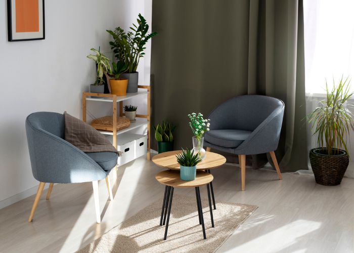Modern living room with gray chairs, a wooden coffee table, and decorative plants.